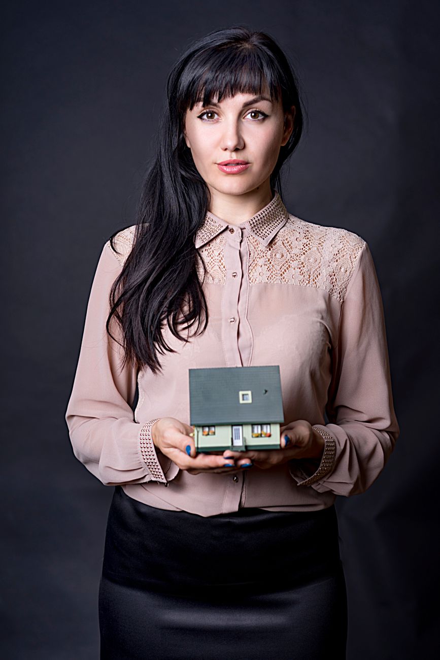 Real estate professional holding a model house representing email marketing lead nurturing